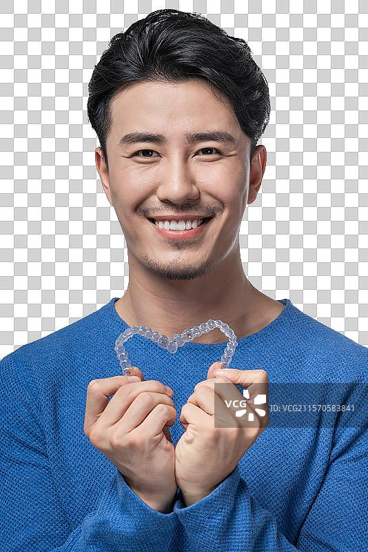 年轻男子拿着透明牙套图片素材