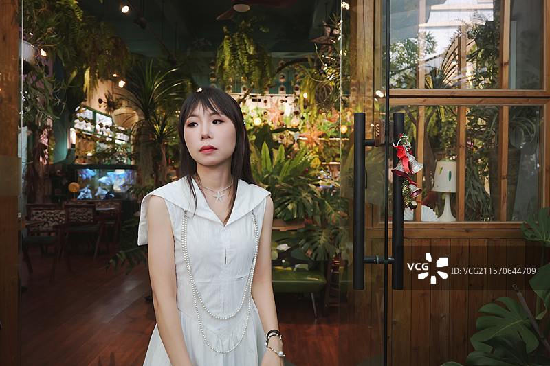 在绿植主题咖啡馆的年轻女性图片素材