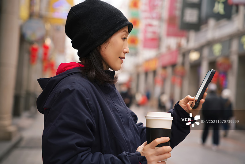 城市街头使用智能手机的女性图片素材