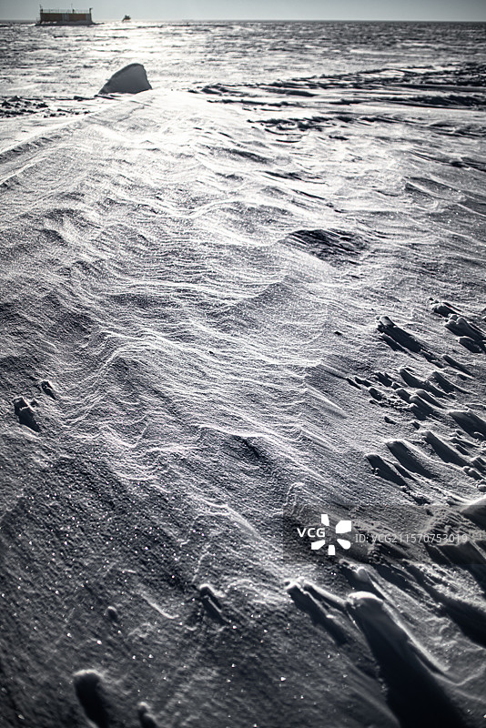 位于东南极的圆顶C高原上，康科迪亚站的地面受到风的影响而形成。背景中可以看到一个包含测量仪器的科学实验室。康科迪亚南极科学研究站，圆顶C高原，东南极。图片素材
