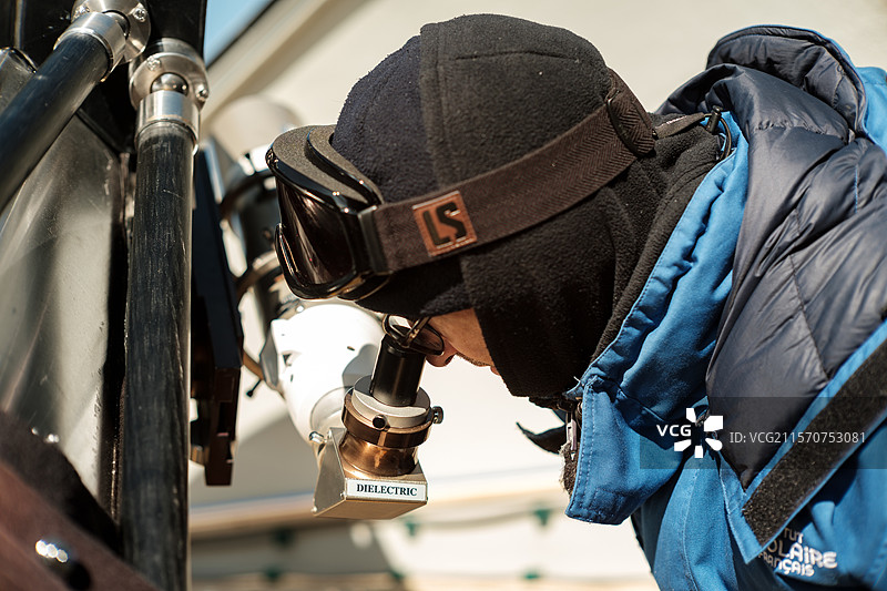 卡里姆·阿加比检查他的望远镜是否对焦。康科迪亚南极研究站，Dome C高原，东南极。图片素材