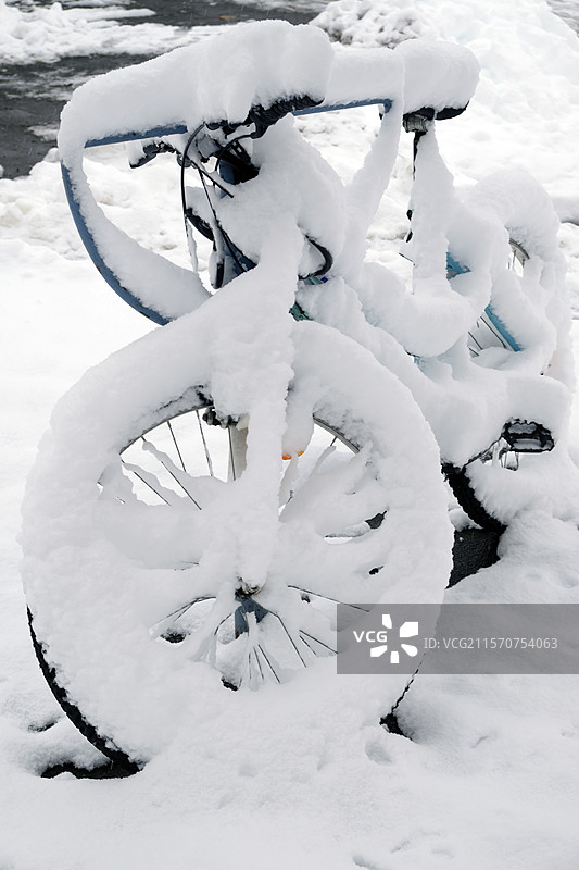 冬季雪中的自行车，停放在人行道上，法国贝尔福特，贝尔福特地区图片素材