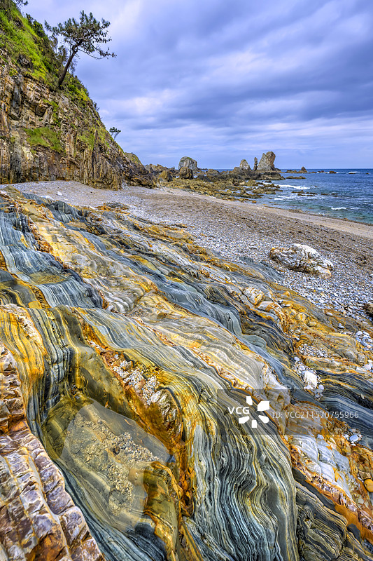 西班牙(阿斯图里亚斯)沉默海滩的多色地层。显著的构造上笔直的石英岩、砂岩和页岩地层,来自古生代(寒武纪/奥陶纪) - 沉默海湾,阿斯图里亚斯,西班牙图片素材
