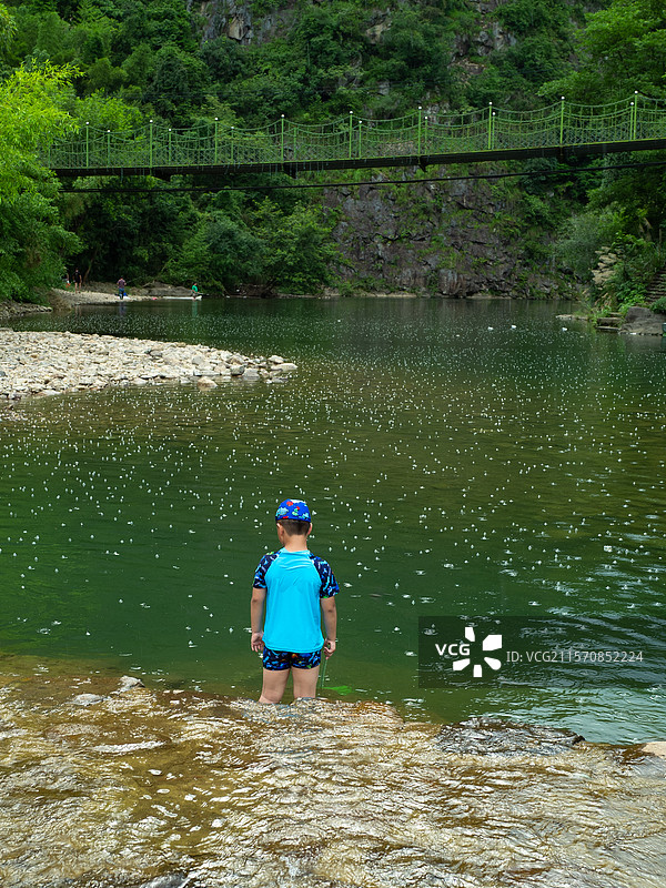 雨中河边捞鱼小孩背影图片素材