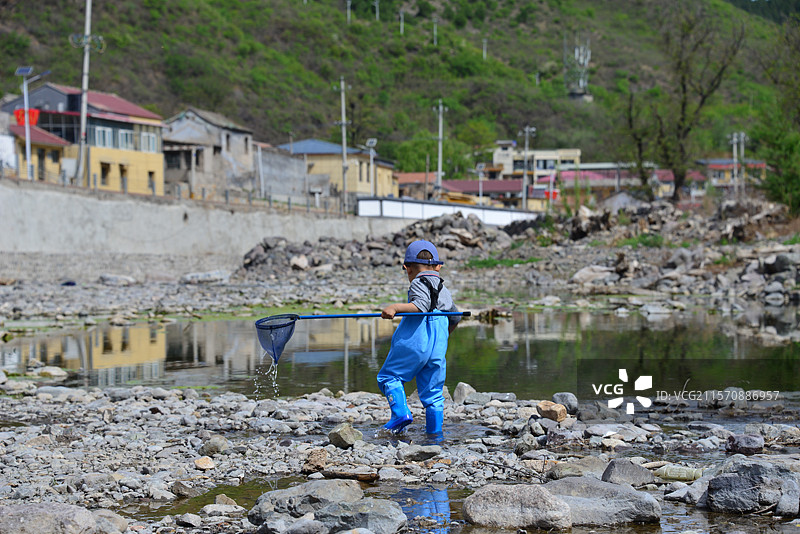 在小河里玩耍戏水捕鱼的儿童图片素材