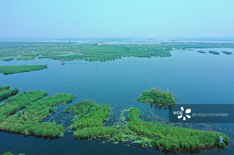 浩瀚银波鹭雁翔，接天芦荻藕风香 云边舟影衔鸬鹚，泽畔鱼梭和鹭吭 客醉莲漪疑入梦，城融碧水自生光图片素材