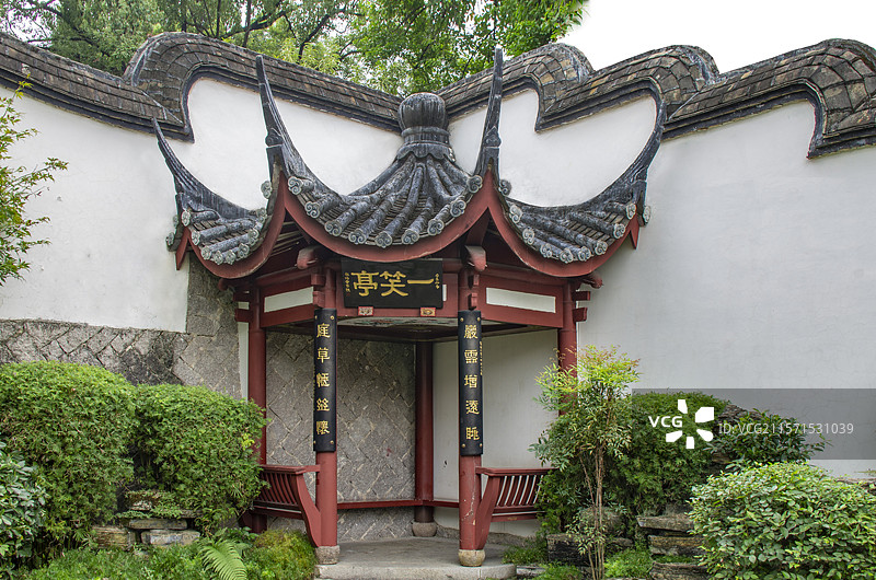 精巧典雅的中国福建福州乌山公园两堵风火墙直角拐角处奇特少见的五柱木质结构的四分之一圆形形状的一笑亭图片素材