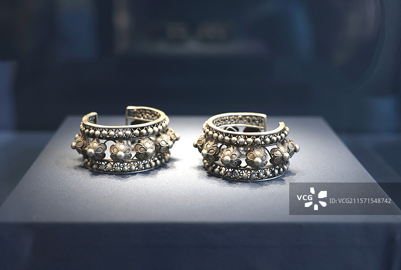 桌子上摆放的银饰，镂空乳钉纹银手镯图片素材