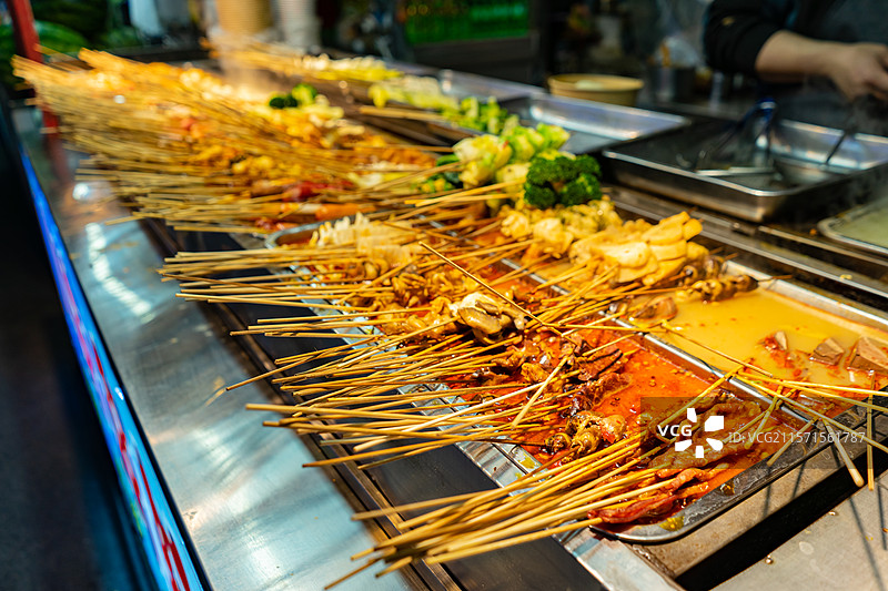 中国餐饮行业饮食产业，传统经典中国食品，夜市锅里的麻辣串炸串美食特写，户外夜晚无人图像图片素材
