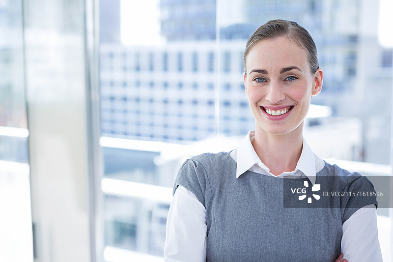 身穿商务服装的女商人在阳台上双臂交叉，玻璃栏杆旁，留有空白空间图片素材