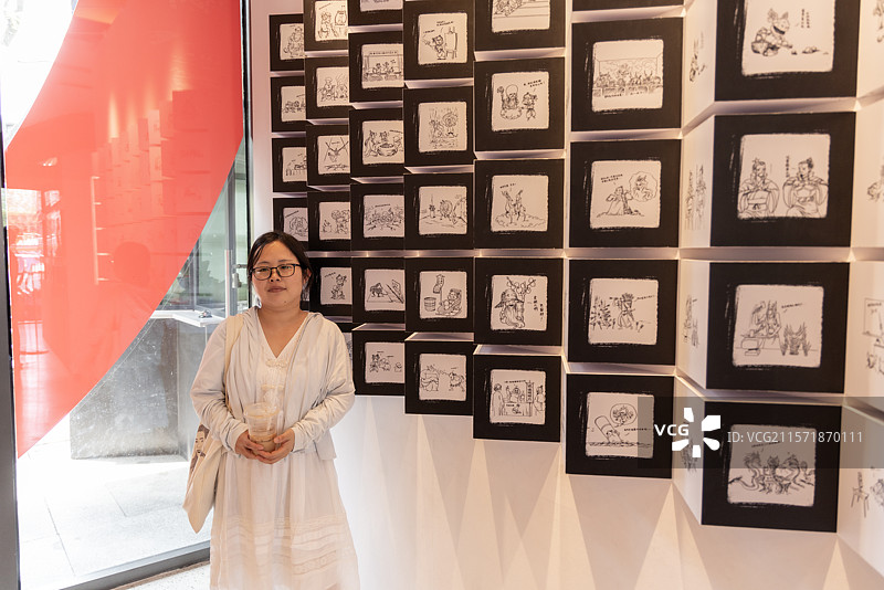 女性在动画电影哪吒幕后创作展里打卡原画墙图片素材