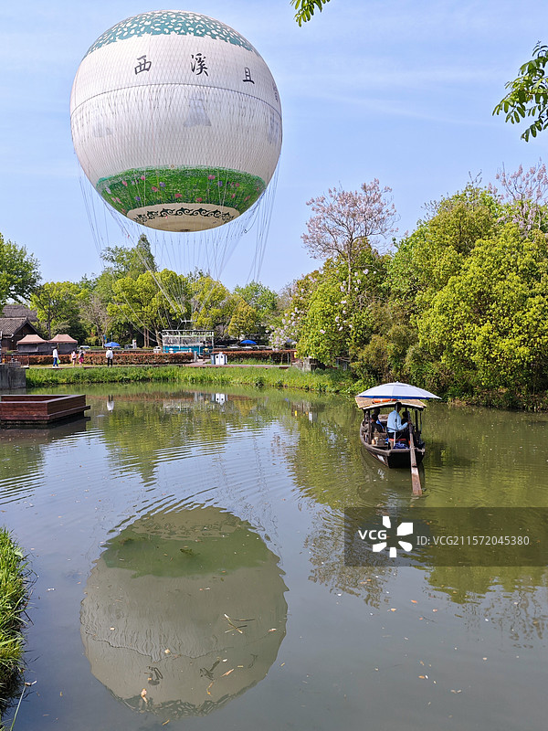 杭州西溪湿地河渚街区域的氦气球和手划船，水面上的观光热气球图片素材
