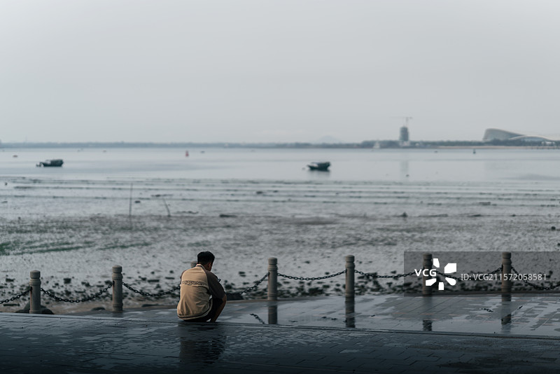 一个人孤独的坐在海边图片素材