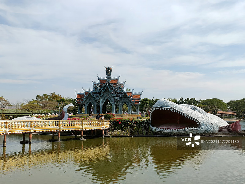 泰国暹罗古城湖面上的巨型鱼雕塑与寺庙图片素材