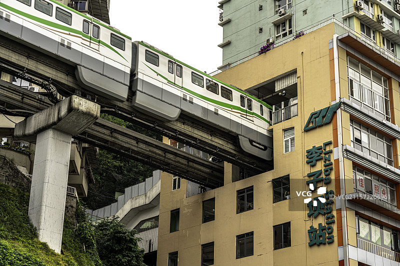重庆著名地标李子坝轻轨站，列车穿楼而过，展现独特城市交通与建筑融合的壮观景象。图片素材