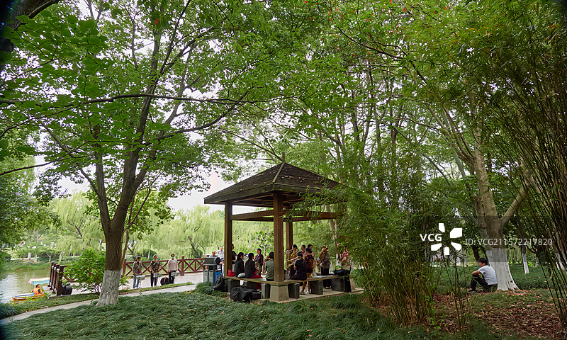 一支市民铜管小乐队在公园凉亭中排练，绿荫环绕，气氛安静自然图片素材