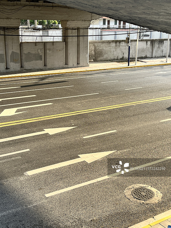 阳光下无人无车的城市车道标志线图片素材