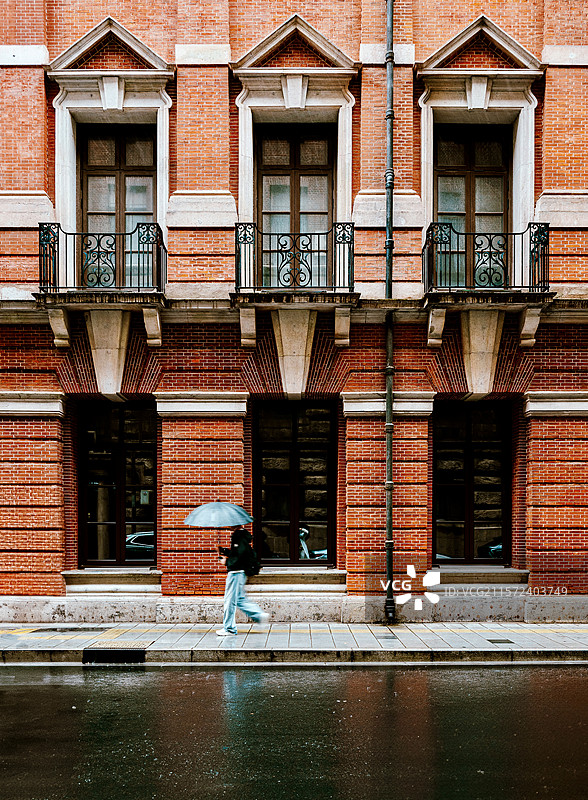 雨中漫步在红砖老街前图片素材
