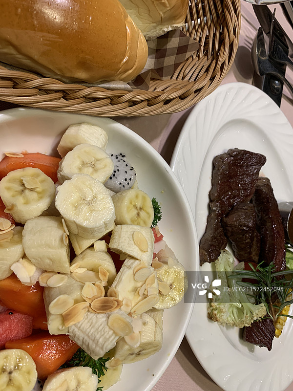 水果沙拉和面包和牛扒的特写图片素材