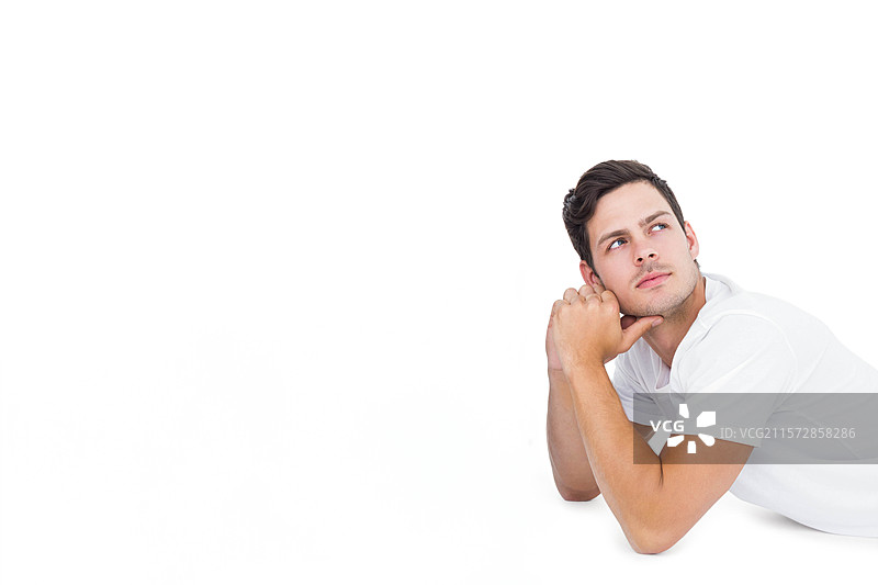 穿着白色 polo 衫的男子双肘支撑在工作台上，向右侧仰望，留有空白空间。图片素材