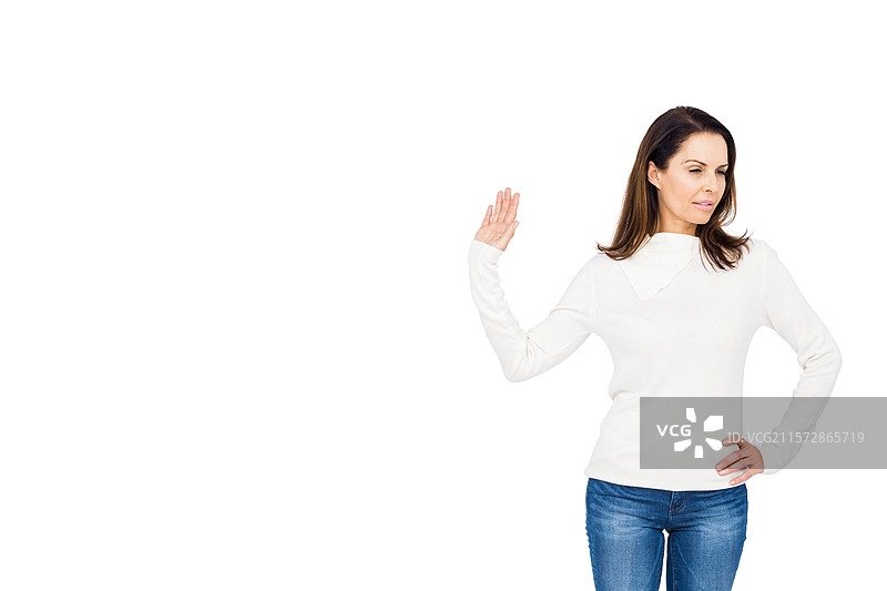 成熟的女性在摄影工作室中右手向外伸展，左臂搭在臀部，留有空白空间图片素材