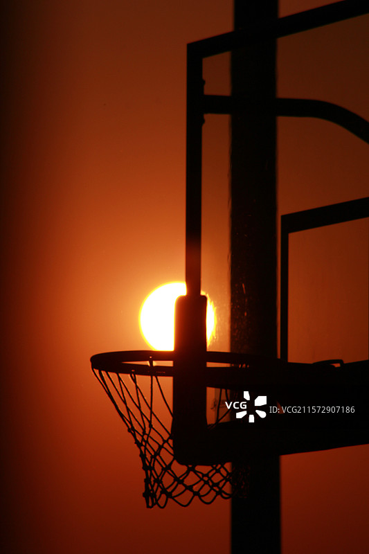 太阳像篮球一样进入球框图片素材