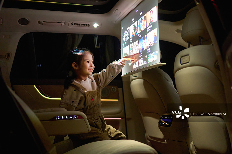 一位东方小女孩在汽车里触摸电子显示屏图片素材