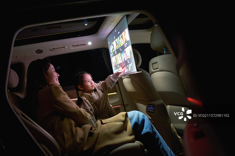 母女两人在汽车里触摸电子显示屏图片素材
