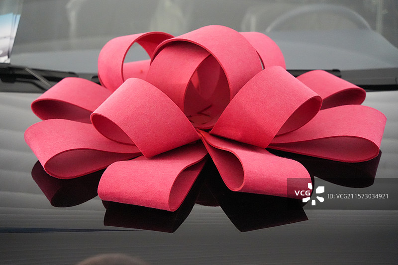 汽车引擎盖上的红色表彰大红花图片素材