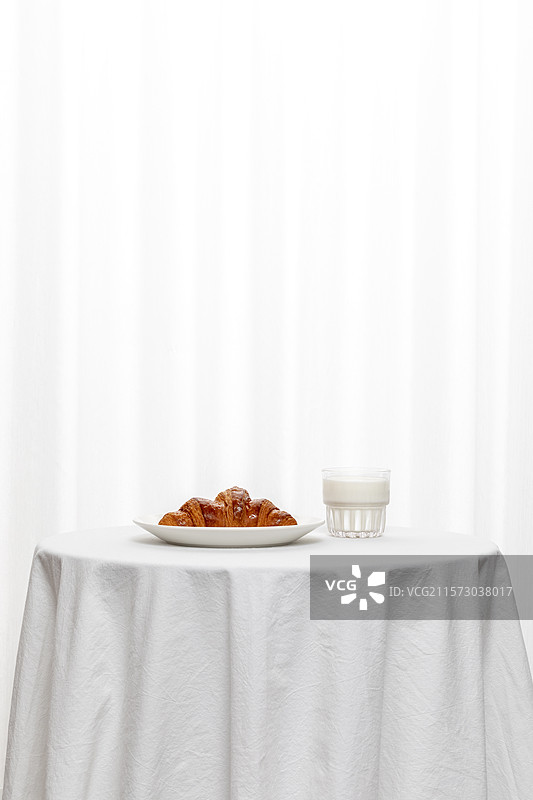 放在桌子上的盘子里的面包和牛奶图片素材