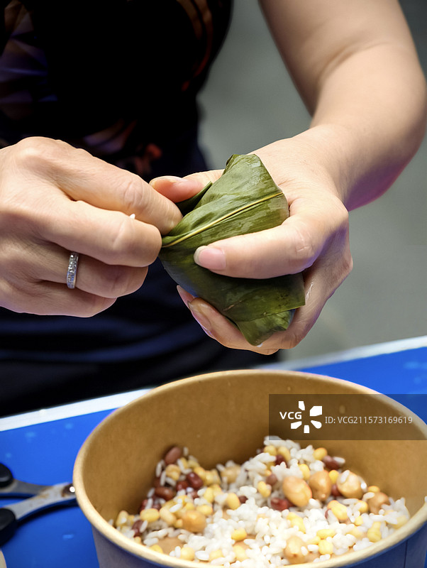 包粽子。端午节小区物业搞活动包粽子迎端午。图片素材