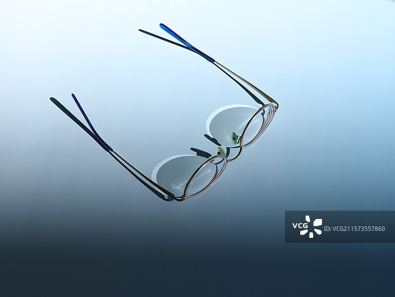 蓝色桌面上的一副近视眼镜图片素材