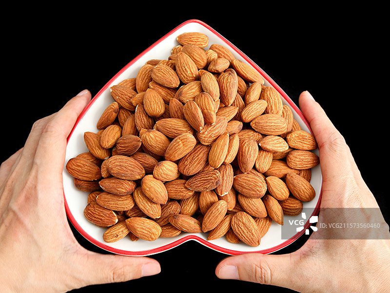 黑色背景上的一盘子营养坚果年货巴旦木仁图片素材