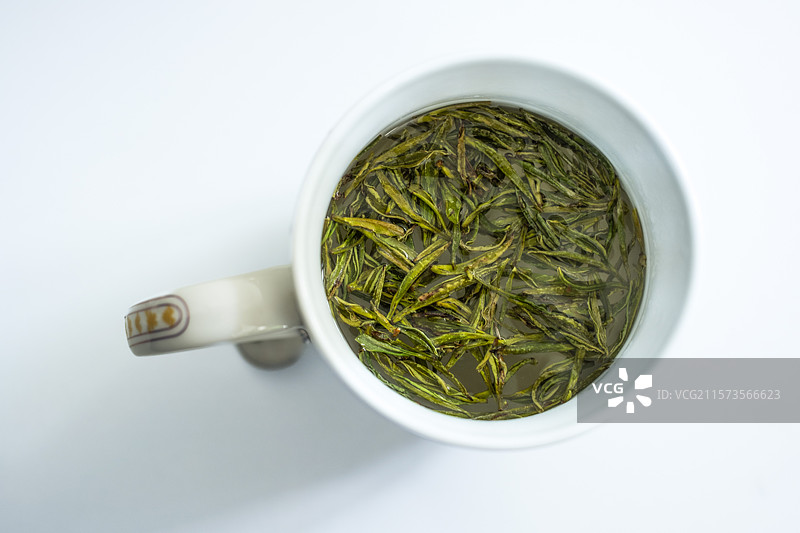 泡有绿茶茶叶的瓷杯图片素材
