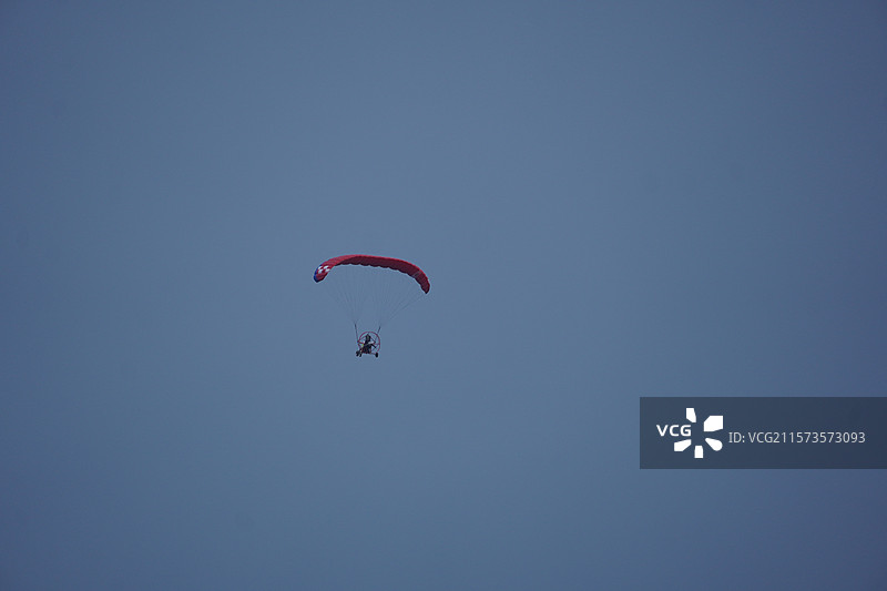 晴空中人滑翔伞的低角度视角图片素材