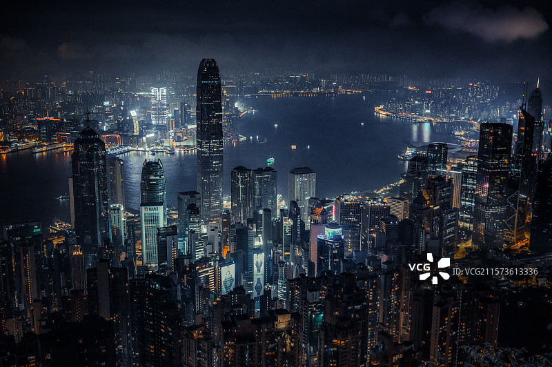 维多利亚港蜿蜒伸展，夜雾笼罩在高楼与海面之间。所有建筑灯火通明，像是深海里的浮游生物，静谧又璀璨。图片素材