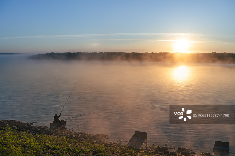 初夏清晨黑龙江呼玛县黑龙江畔边境，初升的太阳照在江面的晨雾，有人在江畔钓鱼，界江对岸就是俄罗斯图片素材