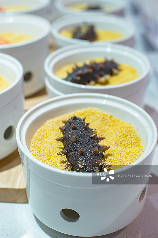 中国蔬菜篮子拍摄主题，一碗黄色的小米和铺在上面的一只海参，室内无人图像摄影图片素材