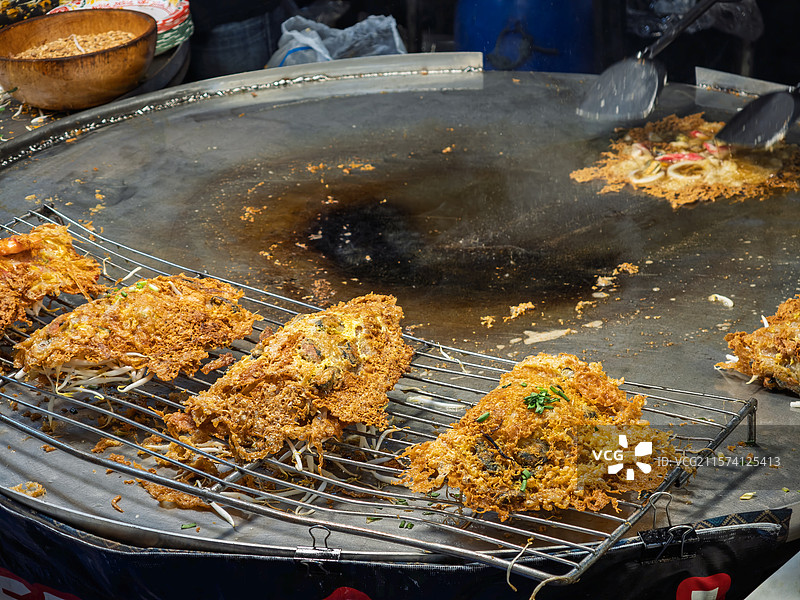泰国街头美食摊上正在烹饪的酥脆泰式蚝烙图片素材