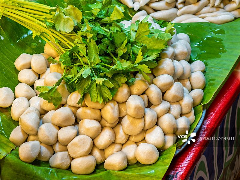 摆放在绿色香蕉叶上的新鲜泰式鱼丸和鱼饼图片素材