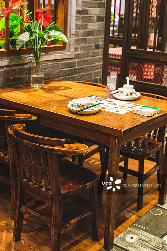 中国餐饮餐厅饭店饭馆行业，空的餐桌拍摄主题，中国传统木制圆桌上的透明玻璃和餐具，室内无人图像摄影图片素材
