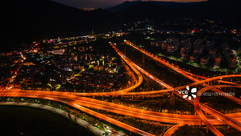 航拍昆明高峣立交桥充满活力的夜景，展示照明的道路和城市灯光图片素材