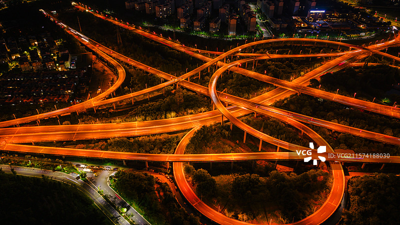 航拍昆明高峣立交桥充满活力的夜景，展示照明的道路和城市灯光图片素材