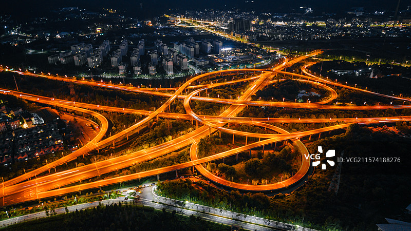 航拍昆明高峣立交桥充满活力的夜景，展示照明的道路和城市灯光图片素材