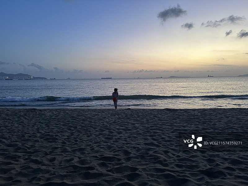 日落时三亚湾海滩上的人们图片素材