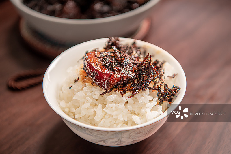 一块梅干菜烧肉放在一碗白米饭上图片素材