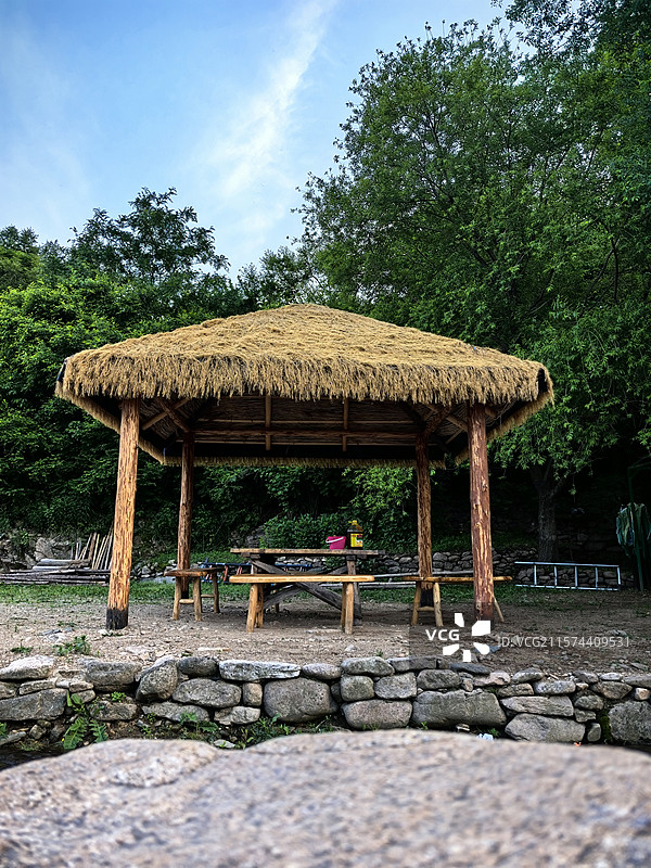 在乡村大山之间的茅草亭中烧烤度假图片素材