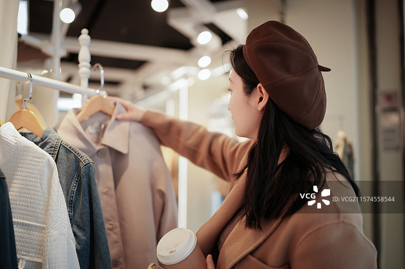女子在精品店挑选服装图片素材