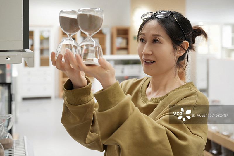 女子店内挑选沙漏图片素材