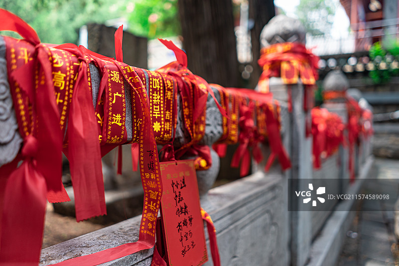 中国传统文化拍摄主题，栏杆上悬挂着一堆成一排的红色丝带许愿带，户外白昼无人图像摄影图片素材